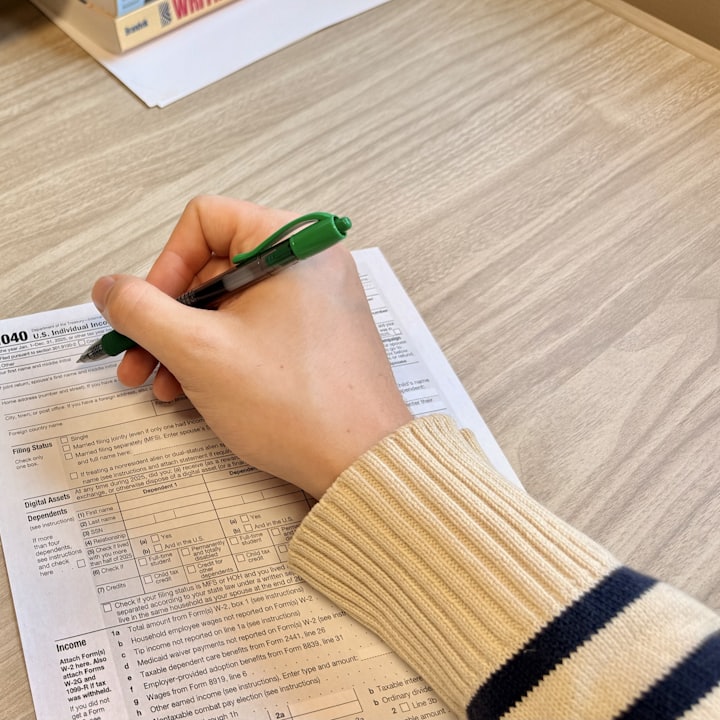 Una mano revisa y anota sobre documentos en un escritorio.